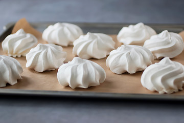 White meringues on brown paper. Preparation for dessert Pavlova.