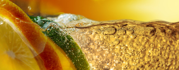 Carbonated drink or cocktail with lemon and lime, abstract splashing.