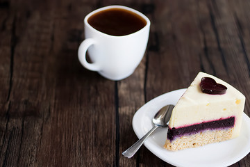 Gluten-free and sugar-free vegan cake on a white plate and white sashka coffee on a brown wooden table.
