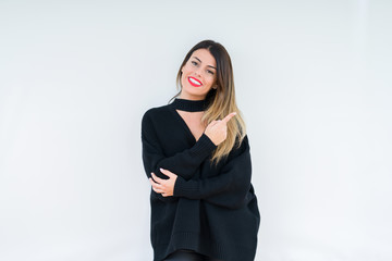 Young woman wearing casual sweater over isolated background with a big smile on face, pointing with hand and finger to the side looking at the camera.