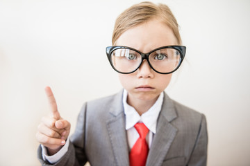 Close-up of comic portrait of boss girl with index finger on white background. Selective focus