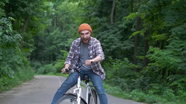 Young man with bicycle having outdoor fun. retro vintage style image. Happy hipster guy smile while riding bike on the road. Cycling and adventure traveling lifestyle