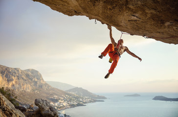 Young man climbing challenging route in cave