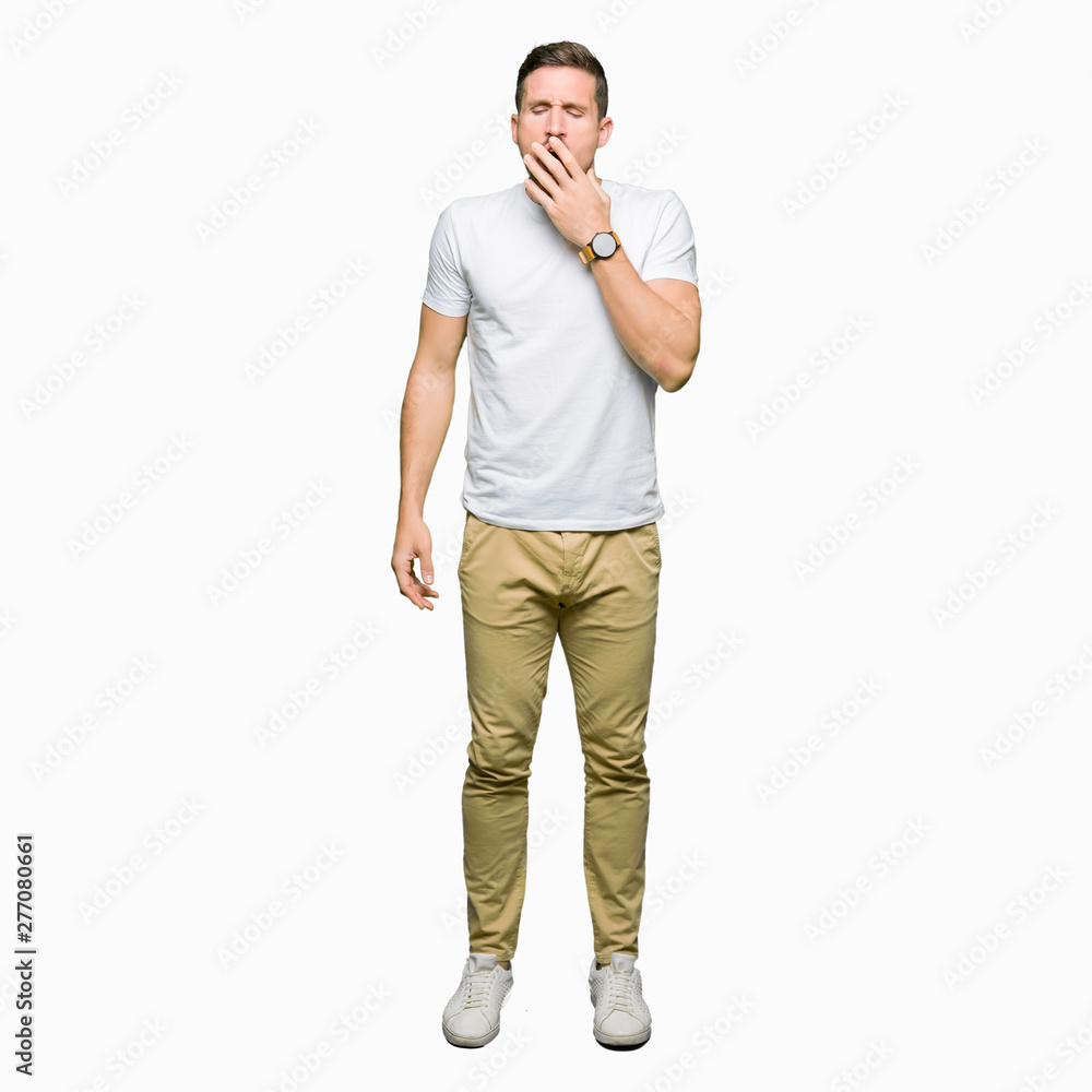 Wall mural handsome man wearing casual white t-shirt bored yawning tired covering mouth with hand. restless and