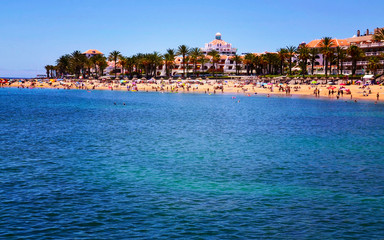 Fototapeta na wymiar View of Playa del Camison beach with turquoise water and yellow sand in Las Americas, Tenerife,Canary Islands, Spain.Summer vacation or travel concept