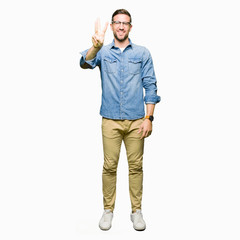 Handsome man wearing glasses showing and pointing up with fingers number three while smiling confident and happy.