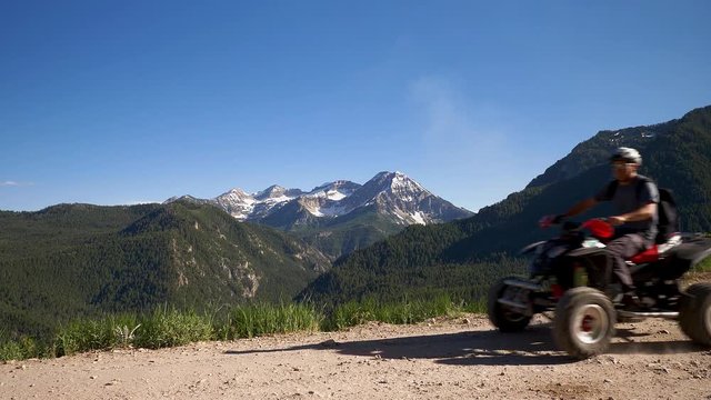 Man drives along a scenic mountian trail on a four-wheeler