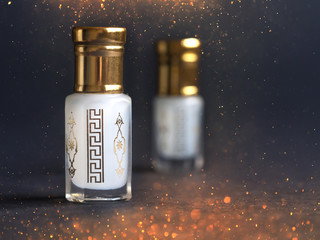 Concentrated perfume in a mini bottle on the black background - obrazy, fototapety, plakaty