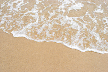 Fototapeta na wymiar Wave of the sea on the sand beach background and texture