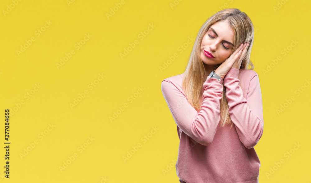 Sticker Young beautiful blonde woman wearing pink winter sweater over isolated background sleeping tired dreaming and posing with hands together while smiling with closed eyes.