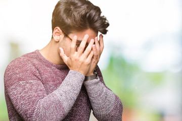 Young handsome man wearing glasses over isolated background with sad expression covering face with hands while crying. Depression concept.