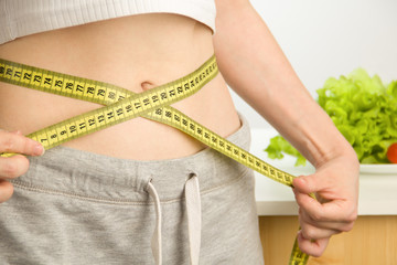 Woman measuring her body. Diet and healthy lifestyle. Сlose up.