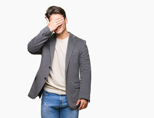 Young business man wearing glasses over isolated background smiling and laughing with hand on face covering eyes for surprise. Blind concept.