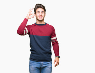 Fototapeta premium Young handsome man over isolated background smiling positive doing ok sign with hand and fingers. Successful expression.