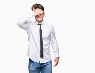 Young business man wearing glasses over isolated background smiling and laughing with hand on face covering eyes for surprise. Blind concept.
