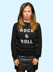 Beautiful middle age woman wearing rock and roll sweater depressed and worry for distress, crying angry and afraid. Sad expression.