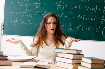 Young female math teacher in front of chalkboard  
