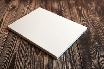 Artistic white blank cotton canvas on brown wooden background. Mockup