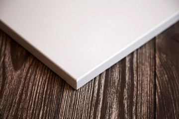 Fototapeta premium Artistic white blank cotton canvas on brown wooden background. Mockup