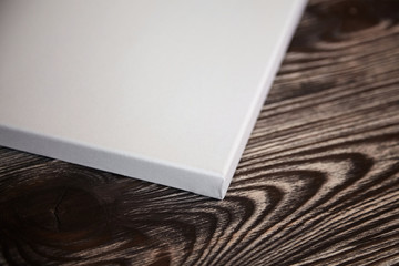 Artistic white blank cotton canvas on brown wooden background. Mockup