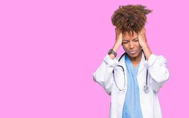 Young african american doctor woman over isolated background suffering from headache desperate and stressed because pain and migraine. Hands on head.