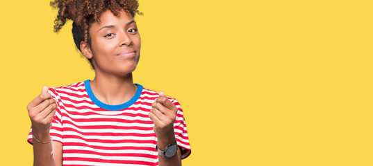 Beautiful young african american woman over isolated background Doing money gesture with hand,...