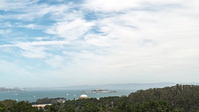 Time lapse view of San Francisco Bay on a sunny weekend afternoon.  Sailboats racing near Alcatraz.  High clouds moving across light blue sky.  Zoom in towards the bay.