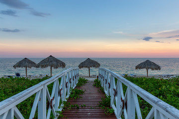 Beautiful view of a wooden path leading to the sandy beach on the Caribbean Sea in Cuba during a...