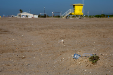 plastic rubbish on the coastline with lifeguard tower