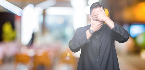 Young Christian priest over isolated background Covering eyes and mouth with hands, surprised and shocked. Hiding emotion