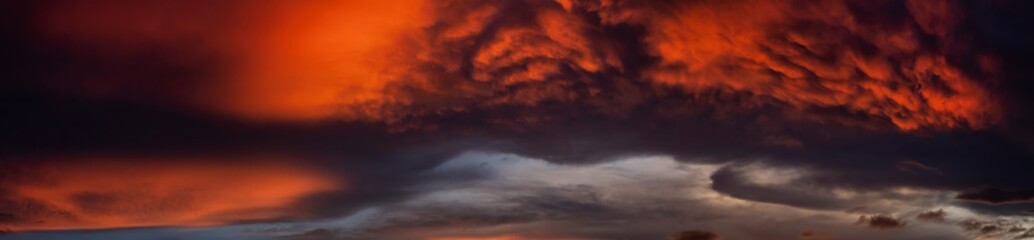 Dramatic Panoramic View of a cloudscape during a dark and colorful sunset. Taken over Beach Ancon in Trinidad, Cuba.