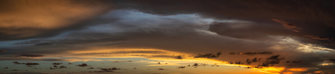 Dramatic Panoramic View of a cloudscape during a dark and colorful sunset. Taken over Beach Ancon in Trinidad, Cuba.