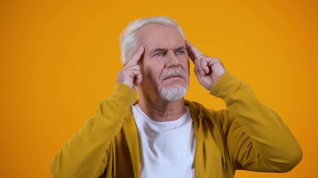 Senior male telepathist touching temples, trying to read thoughts, mentalist