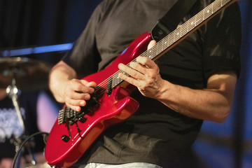 Man lead guitarist playing electrical guitar on concert stage .