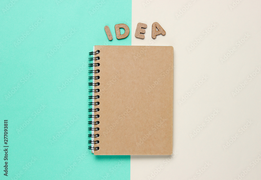 Poster i have an idea! notebook with craft paper with word idea on colored pastel background. top view