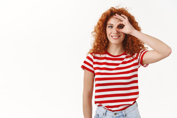Everything perfect. Lucky upbeat enthusiastic redhead curly woman look through okay sign smiling...