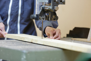 man cutting wood with saw blade
