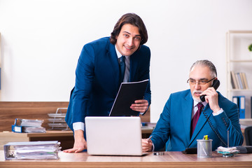 Fototapeta premium Young and old employees working together in the office 