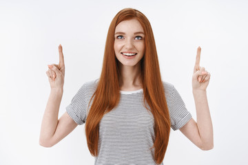 Impressed speechless amused redhead woman wearing striped t-shirt hold breath astonished smiling...