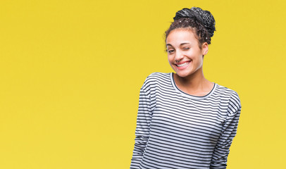 Young braided hair african american girl wearing sweater over isolated background winking looking...