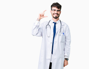 Fototapeta premium Young doctor man wearing hospital coat over isolated background smiling and confident gesturing with hand doing size sign with fingers while looking and the camera. Measure concept.