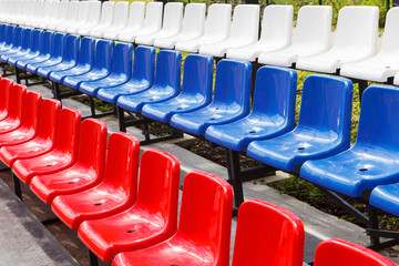 Lots of plastic chairs red, blue and white in the stadium or Playground