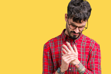Young handsome man wearing glasses over isolated background Suffering pain on hands and fingers,...