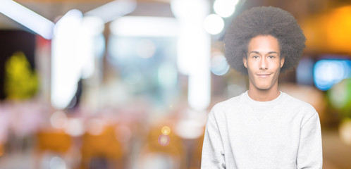 Young african american man with afro hair wearing sporty sweatshirt Smiling with hands palms together receiving or giving gesture. Hold and protection