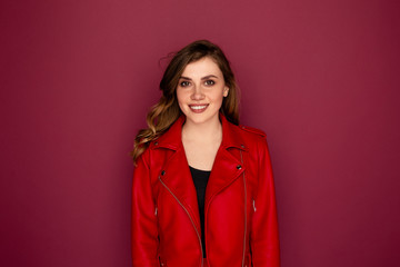 Portrait of pretty young woman in the red clothes isolated over the dark pink background