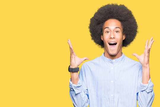 Young African American Man With Afro Hair Celebrating Crazy And Amazed For Success With Arms Raised And Open Eyes Screaming Excited. Winner Concept