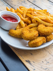chicken nuggets with french fries, ketchup on wooden background
