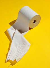 Roll of toilet paper on a yellow background.