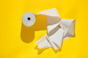 Roll of toilet paper on a yellow background.