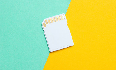 Mini SD memory card on blue yellow background close up